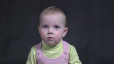 Cute baby with water bottle on black background 