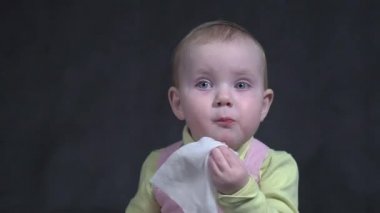 The child eats a banana. Portrait of a little baby girl close-up.