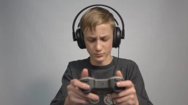 4k a schoolboy in headphones with a joystick from a game console in his hands