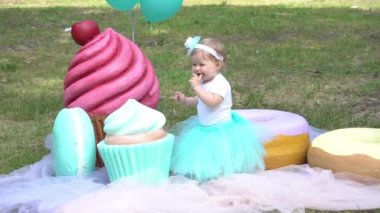 Slow Motion Girl resting in park on background of large lollipops