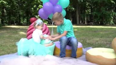 Joyful family relaxing together surrounded by large sweet candies and macaron
