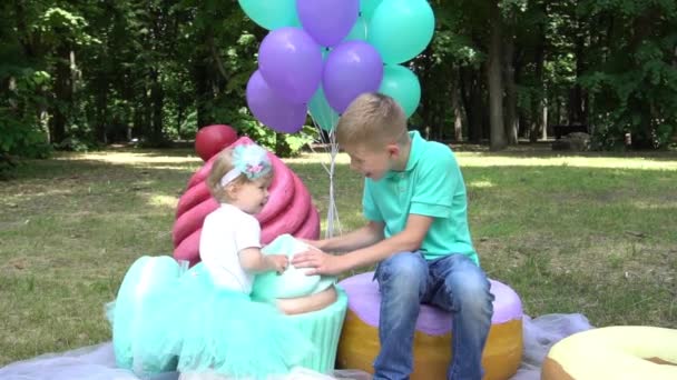 Slow Motion Brother Sister Big Fake Candies Photo Zone Garden — Stock video