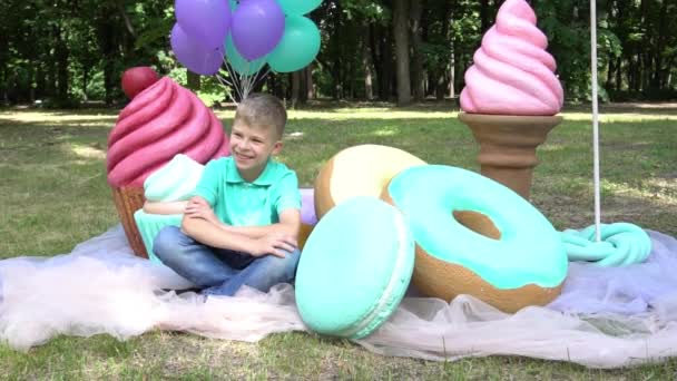 Slow Motion Boy Relaxing Surrounded Large Sweet Candies Macaron — Video Stock