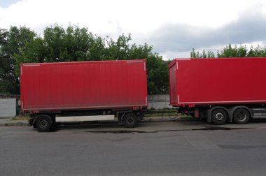 Kırmızı otomobil römorkları. Kırmızı kaplarda yiyecek teslimatı. Mallar kamyonlarla geliyor..