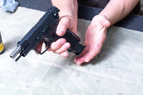 Carguen el arma. Inserta el cargador en la pistola. Pistola en la mano. — Foto de Stock