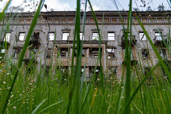 Widok na budynek trawiasty. Widok od dołu do góry. Opuszczony budynek na tle trawy. — Zdjęcie stockowe
