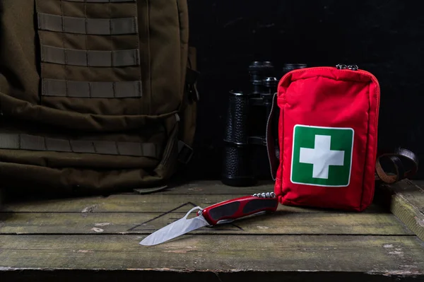 Officer Swiss knife and first aid kit. Military backpack with molle system and knife. Front view.