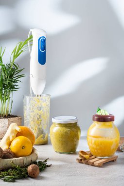 Blender in a bowl. Freshly made jam from honey, nuts and fruits. Ginger, honey and citrus jam. Vertical frame.