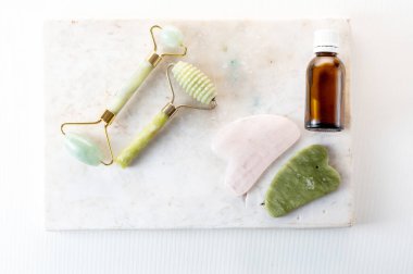 Cosmetic rollers and stones on a granite stand. Red and green stone for cosmetology. Womens skin care. View from above.