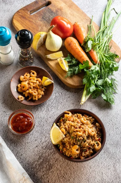 Dish and vegetables. Dish in earthenware. Fresh vegetables on a cutting board. Vertical frame.