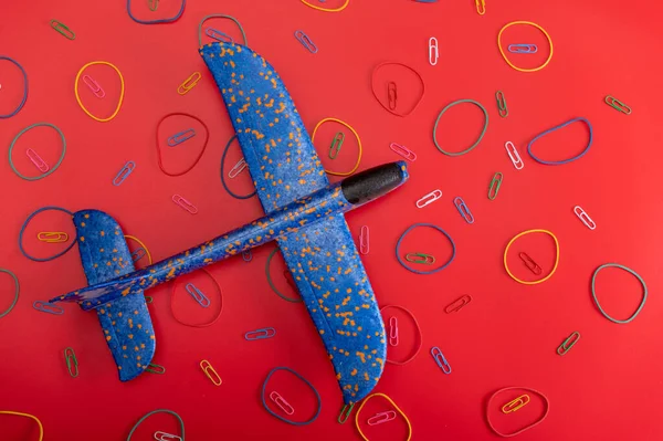 Toys and aircraft. Blue plane on a red background. Airplane and patterns. View from above.