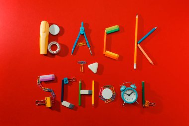 Kırmızı arkaplanda okul kırtasiyesine geri dön. 
