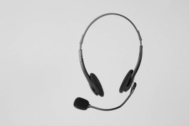 Çevrimiçi teknik destek servisi. Yardım hattını ara. Gri arka planda mikrofon olan kulaklıklar..