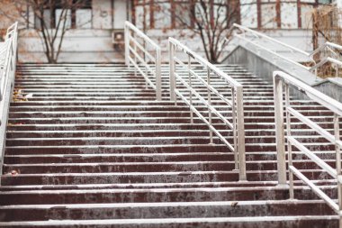 Merdivenlerde şehrin kaldırımında buzlanma. Soğuk havada yağmur yağar.