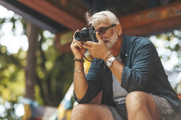 Yaşlı adamın hobisi fotoğrafçılıktır. Emeklilik seyahati, açık hava aktiviteleri. Yaşlıların hayatındaki maceralar.