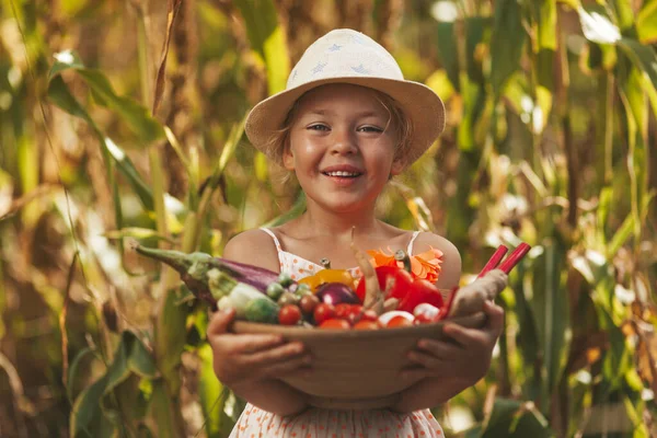 Une Jolie Petite Fille Sourit Tient Des Légumes Cultivés Dans — Photo