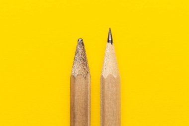Experience and hard work. Erased and new pencil on a yellow background. Education and exam.