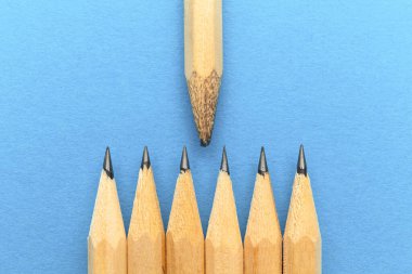 Öğretmen ya da öğretmen konsepti. Mavi arka planda kalemler. Tecrübeli bir lider, takım üzerinde etkisi var..