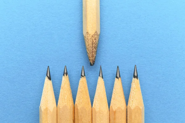 Öğretmen ya da öğretmen konsepti. Mavi arka planda kalemler. Tecrübeli bir lider, takım üzerinde etkisi var..