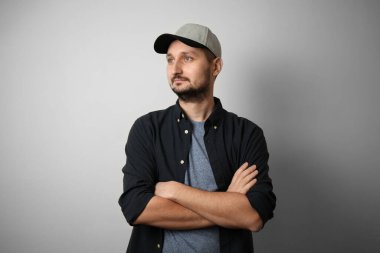 Sakallı ve şapkalı şık beyaz adam kollarını kavuşturdu.. 