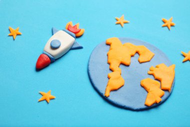 Açık alanda yaratıcı el yapımı plastik roket, astronot rüyaları. Yıldızlar, Dünya gezegeni. Çizgi film sanatı.