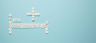 Hastane yatağı ve haç hapları. Hastaneye kaldırılma, hastanede tedavi, sağlık hizmetleri.