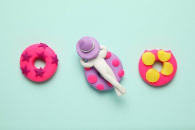 Plastik insanlar havuzda şişme lilonun üzerinde dinleniyorlar. Çizgi film yazı dinlenme ve tatiller.