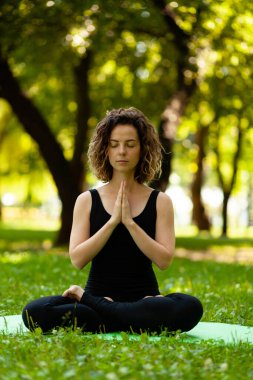 Sabah parktaki kadın huzur içinde meditasyon yapıyor..