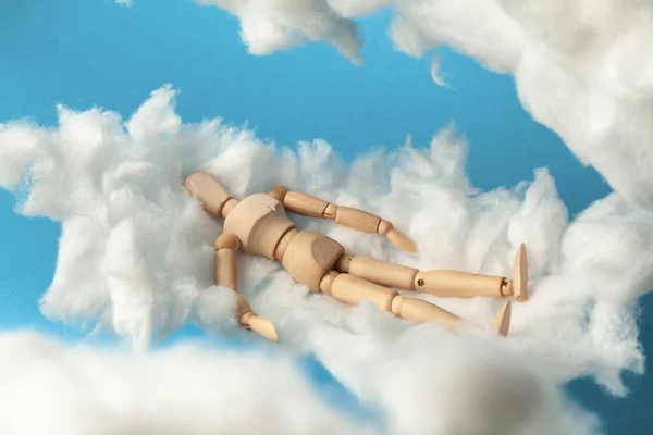 Comfortable dream of toy man on clouds, sweet dreams. Rest on bed.