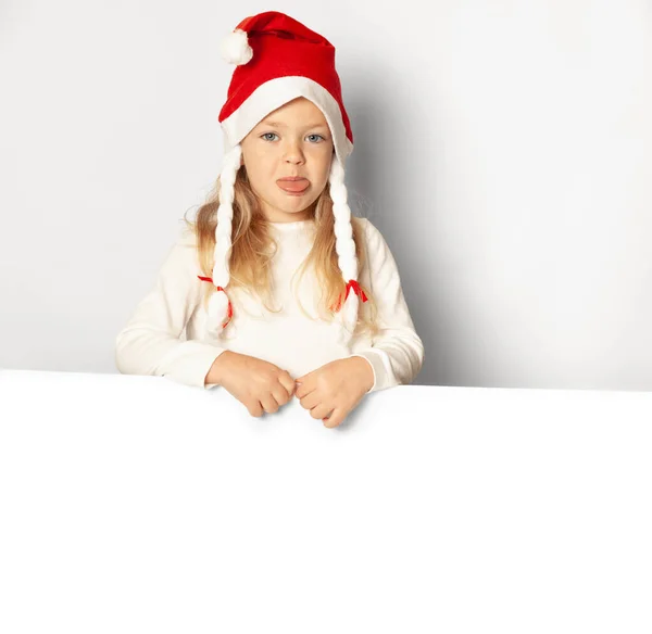 Portrait Little Pretty Girl Upset Santa Hat Sticks Out Tongue — Stock Photo, Image