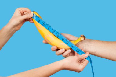 Measuring the size of a banana as a symbol of the male penis. Big dick length. Strong erection and impotence problem.