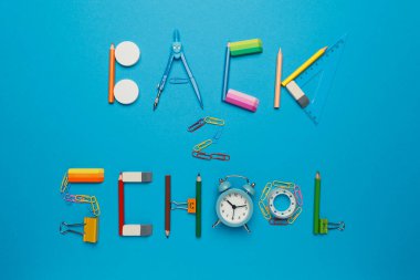 Mavi arkaplanda okul kırtasiyesine geri dön. 