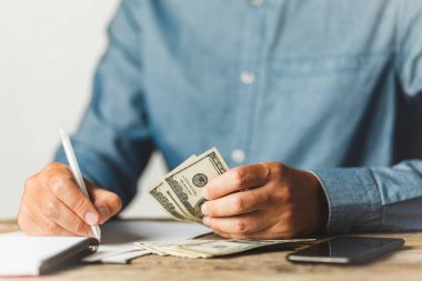 İşadamı dolar sayıyor, para biriktiriyor (biriktiriyor). Gelir artışı, maaş artışı. Emeklilik indirimleri.