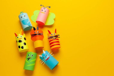 Geri dönüşüm kağıdından yapılmış çocuk kağıtları sarı arka planda. Komik yaratıcı el işi..