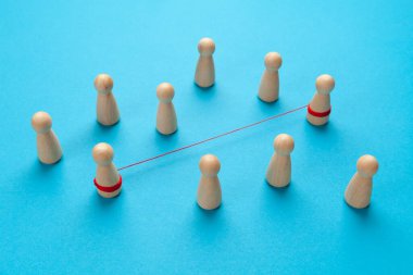 İki insan arasında güçlü bir bağ var. Bir çift figür mavi arkaplanda kırmızı bir iplikle bağlanır.