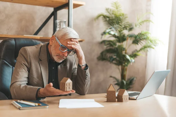 Förfallna Hypotekslån Senior Man Som Håller Ett Modellhus Sina Händer — Stockfoto