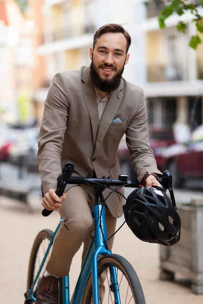 Cheerful businessman rides a bicycle to work. Eco friendly urban transport.