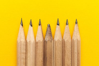 Sarı arka planda kalemler. Eşsizlik, öğrenme kavramı.