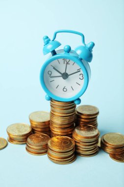 Zaman para konseptidir. Çalar saat ve altın paralar. Nakit yatırımın finansal seçeneği.