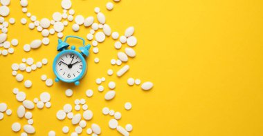 Uyku hapları ve çalar saat, uykusuzluk konsepti. Uykuya dalma sorunu.