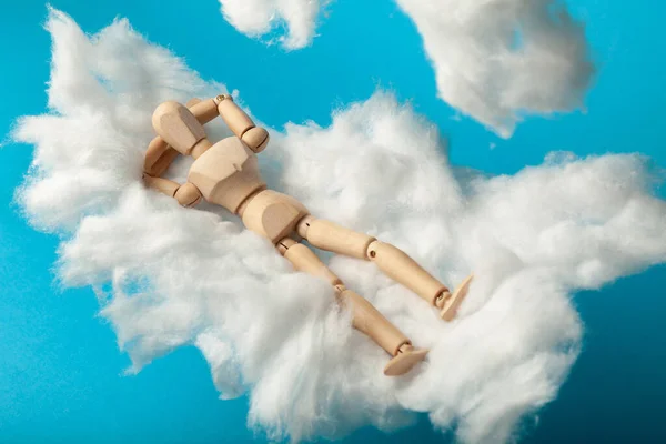 Toy man sleep on fluffy cloud. Freedom and relaxation.