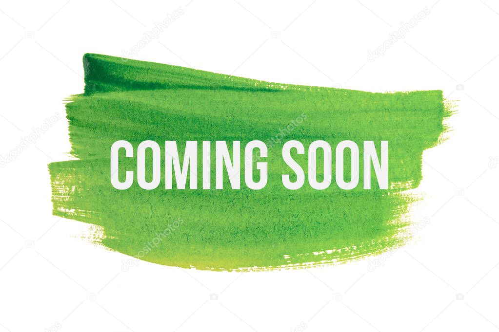 Coming soon on green paint background, isolated on white. Advertising banner concept.