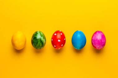 Sarı arka planda parlak paskalya yumurtaları. Retro renkli bahar dekorasyonu.