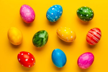 Sarı arka planda parlak paskalya yumurtaları. Retro renkli bahar dekorasyonu.