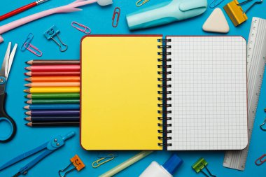 Mavi arkaplanda okul kırtasiyesine geri dön. 