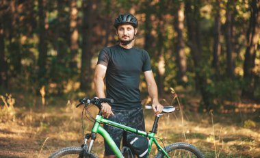 Portrait of a lone cyclist training in the forest. Mountain biking off-road.