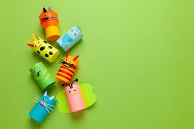 Yeşil arka plandaki kağıt rulolarından ev yapımı hayvan figürleri. Yaratıcı çocuk oyuncakları, sıfır israf. Metin için alanı kopyala.
