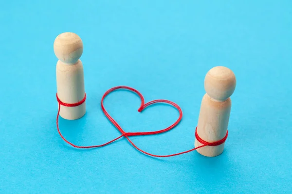 Love relationship. Two figures of people are connected with a thread in the shape of a heart.