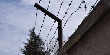 Barbed wire on top of a border wall.