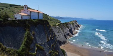 Binalar ve keşişlerle dolu uçurum manzarası.